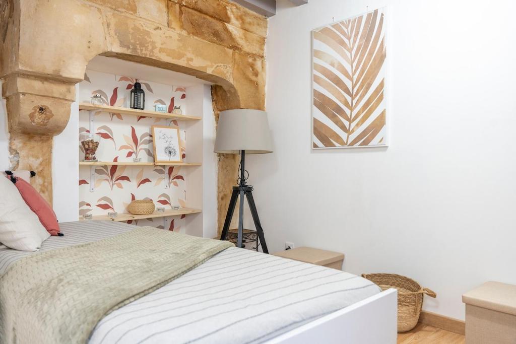 une chambre avec un lit et une table avec une lampe dans l'établissement Petit studio au coeur de Caen, à Caen