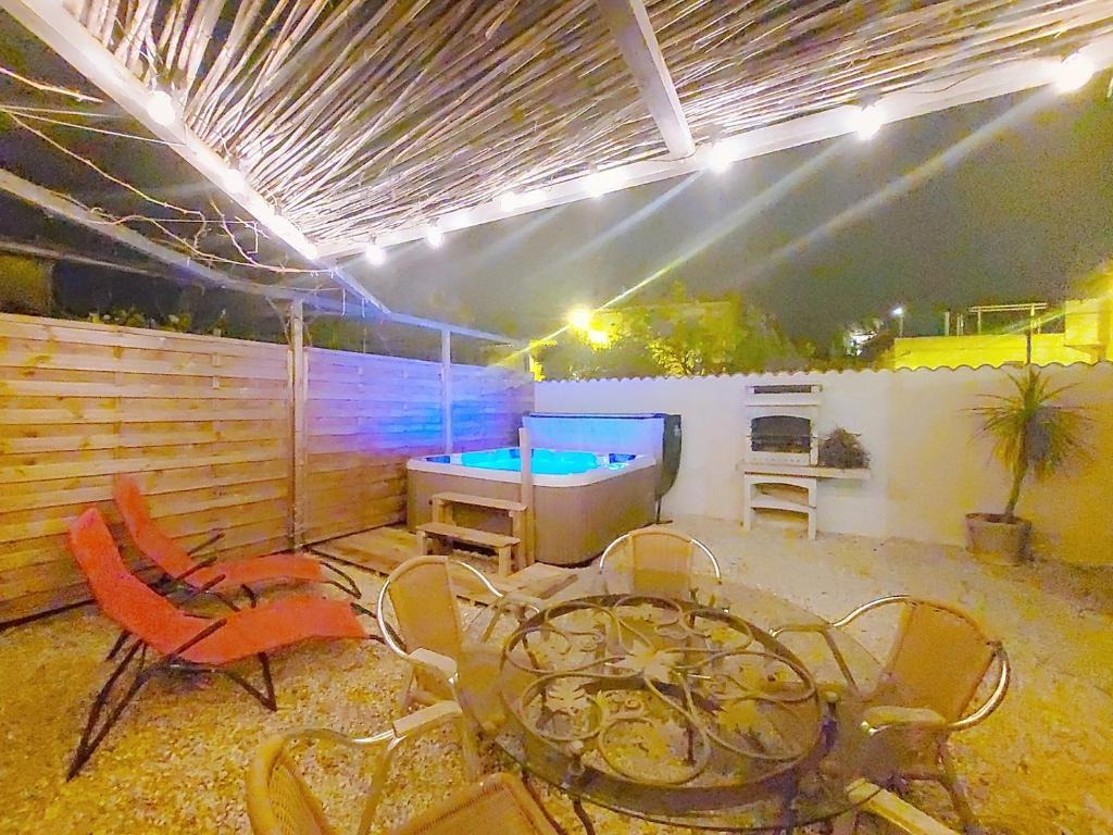 une terrasse avec une table de ping-pong et des chaises dans l'établissement Le 34 degrés sud - 2 chambres - jardinet et jacuzzi, à Thèzan-lès-Béziers