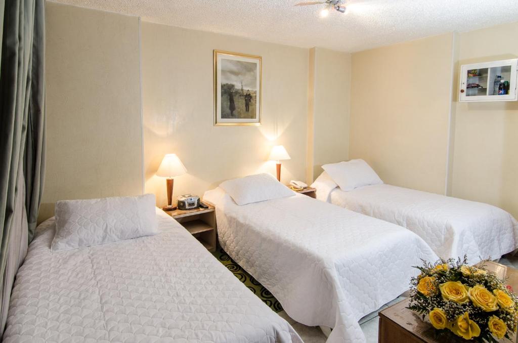 Postel nebo postele na pokoji v ubytování Hotel Inter Bogotá
