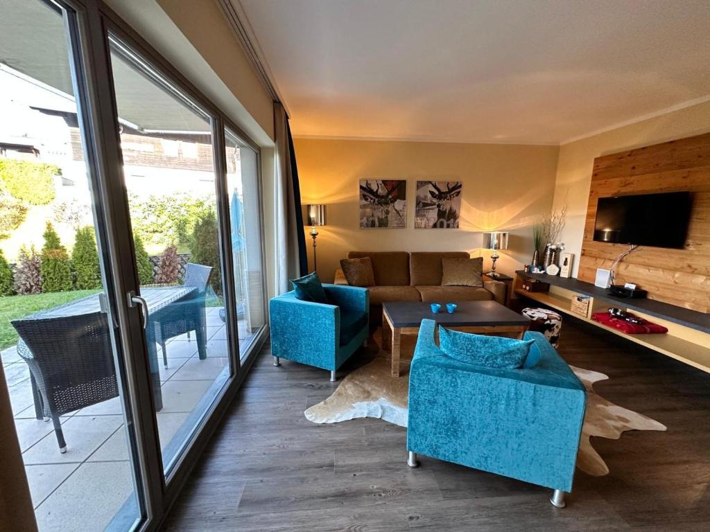 a living room with blue chairs and a couch at Residenz Max mit eigenem Garten in Seefeld in Seefeld in Tirol