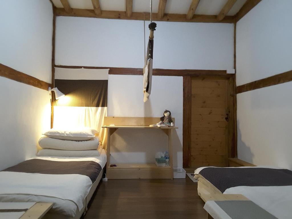 ein Zimmer mit 2 Betten und einem Regal darin in der Unterkunft Yettle Hanok Stay in Gyeongju