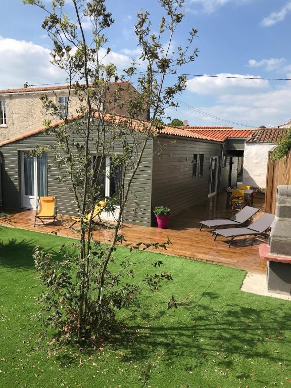 une arrière-cour avec une terrasse en bois et une maison dans l'établissement St Georges d'Oléron maison de village, à Saint-Georges-dʼOléron