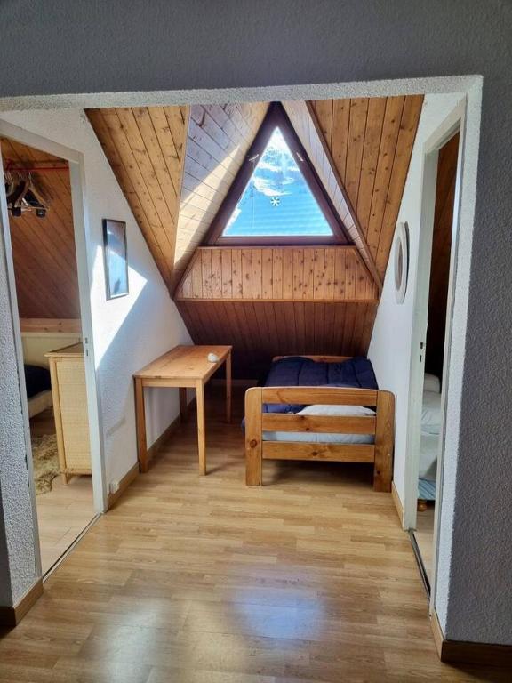 Cette chambre mansardée comprend un lit et une fenêtre. dans l'établissement Cosy appartement 50m from slopes 6 people, à Les Deux Alpes
