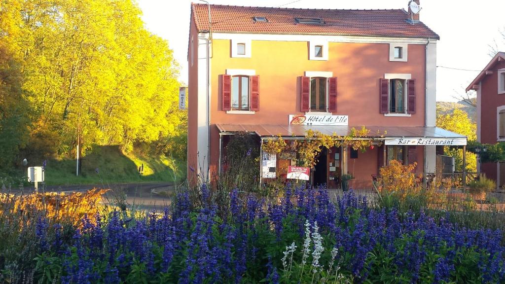 a building with purple flowers in front of a building at Hôtel de l'Île in Jumeaux