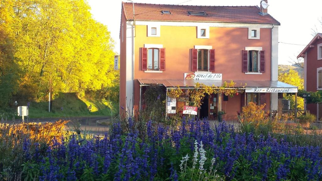 a building with purple flowers in front of a building at Hôtel restaurant de l'Île in Jumeaux