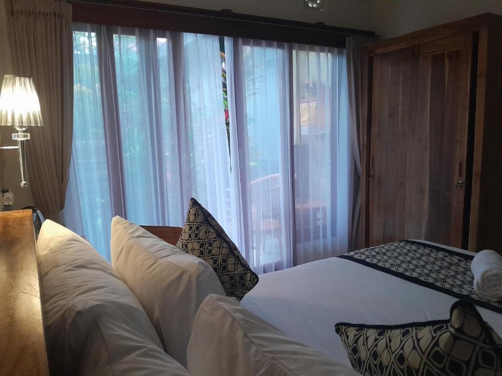 Postel nebo postele na pokoji v ubytování Tirta Sari House