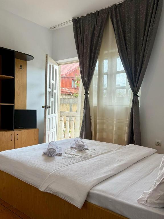 a bedroom with a large white bed with a window at Casa Elenisse in 2 Mai