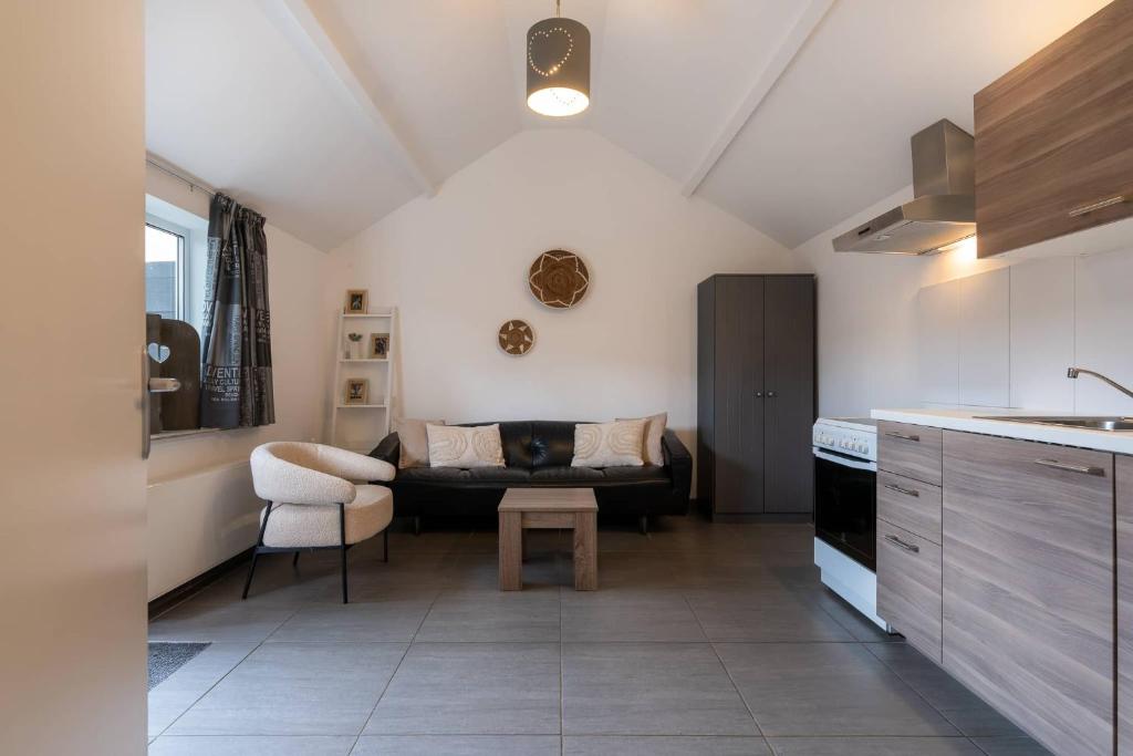 a kitchen and living room with a couch and a table at Hello Zeeland - Vakantiehuis Wijngaardstraat 12A in Domburg