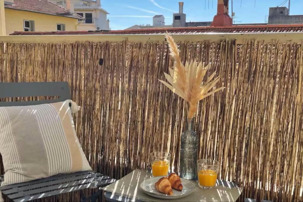 une table avec une assiette de nourriture et deux verres de jus d'orange dans l'établissement Nice T2 with balcony - near beach, à Cannes