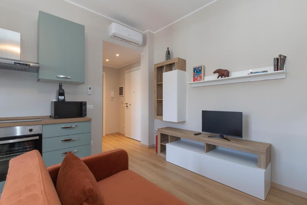 a living room with a couch and a tv and a kitchen at I Host Apartment - Coni Zugna 58 in Milan