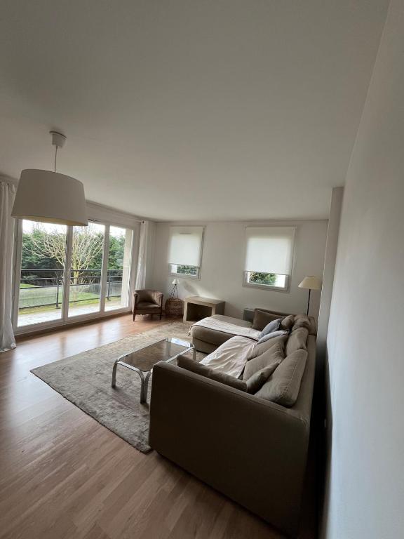 un salon avec un canapé et une table dans l'établissement Bright and spacious 2 bedroom with balcony, à Wasquehal