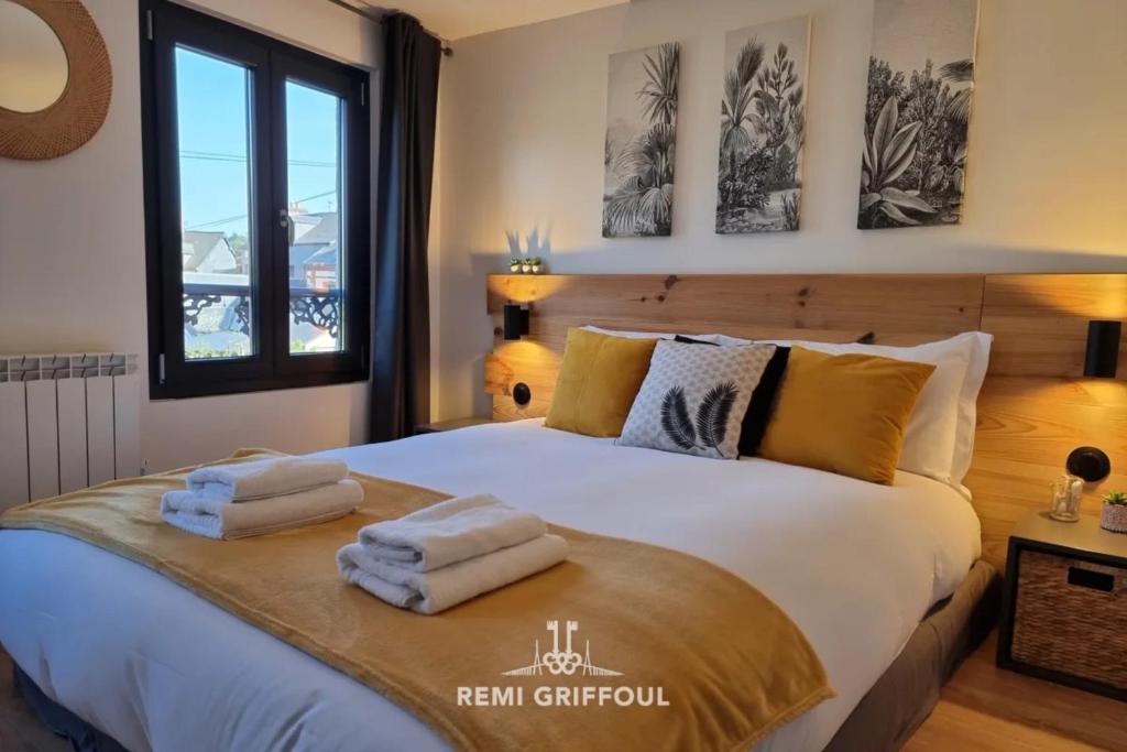 une chambre avec un grand lit avec des serviettes dessus dans l'établissement Rive Sud - Charmante Maisonnette 2 P - Centre Ville, à Honfleur