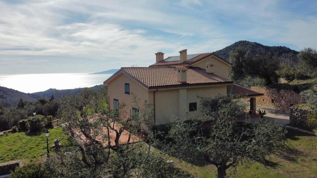 une maison sur une colline avec l'océan en arrière-plan dans l'établissement L'Hermitage- Monte Argentario, à Monte Argentario