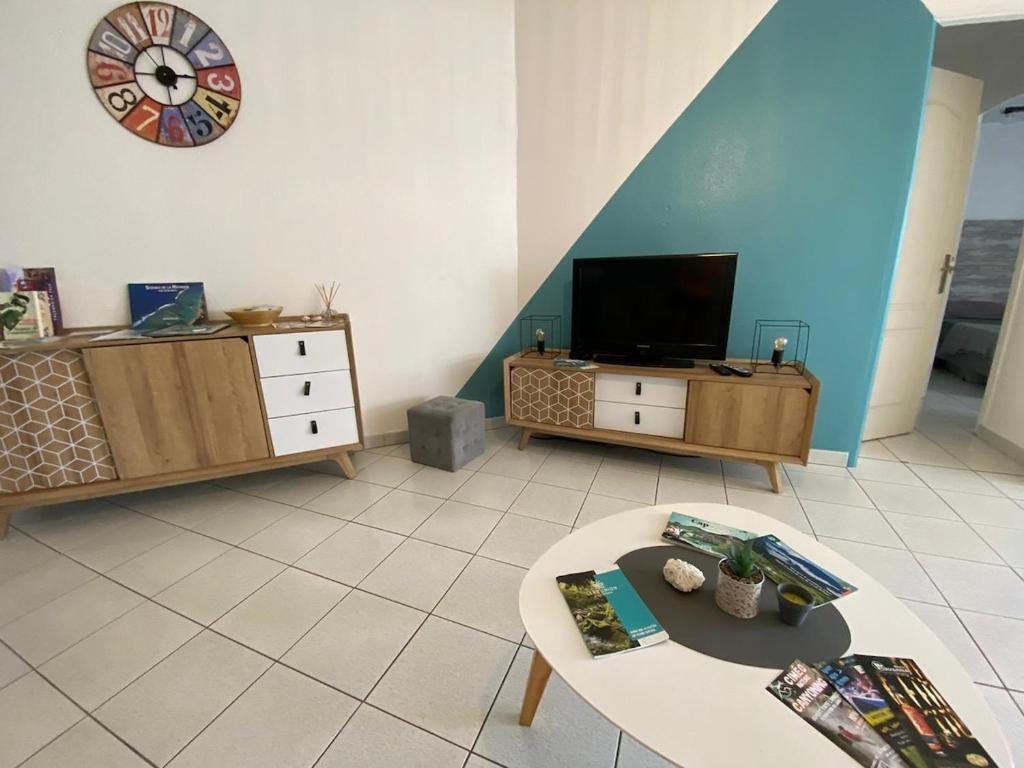 TV a/nebo společenská místnost v ubytování Appart Bénitier 3 étoiles - Ermitage centre à 2 min du Lagon