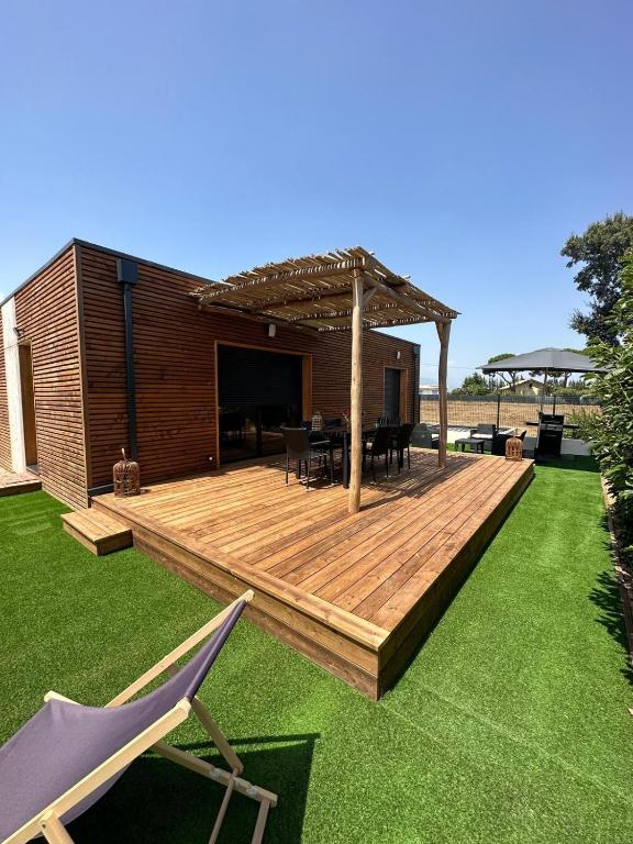 une terrasse en bois avec pergola dans une cour dans l'établissement Casa Juliette Maison bois, à Aléria