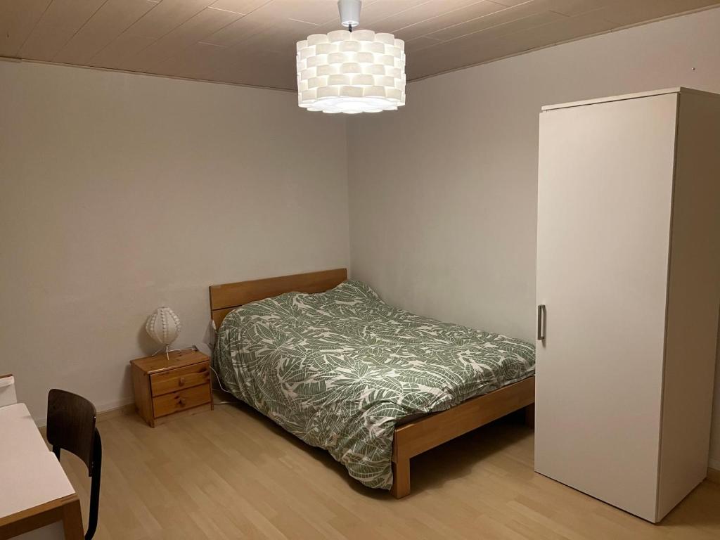 a bedroom with a bed and a cabinet and a lamp at Auberge du rendez vous in Aumont