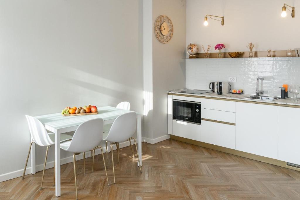 een keuken met een witte tafel en witte stoelen bij HomeThirtyFour in Verona