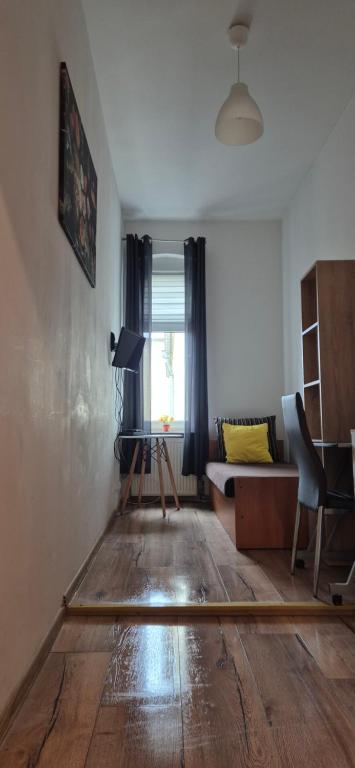 salon z drewnianą podłogą i kanapą w obiekcie Hostel Tulip - pokój nr 8 ze wspólną łazienką i kuchnią w Szczecinie