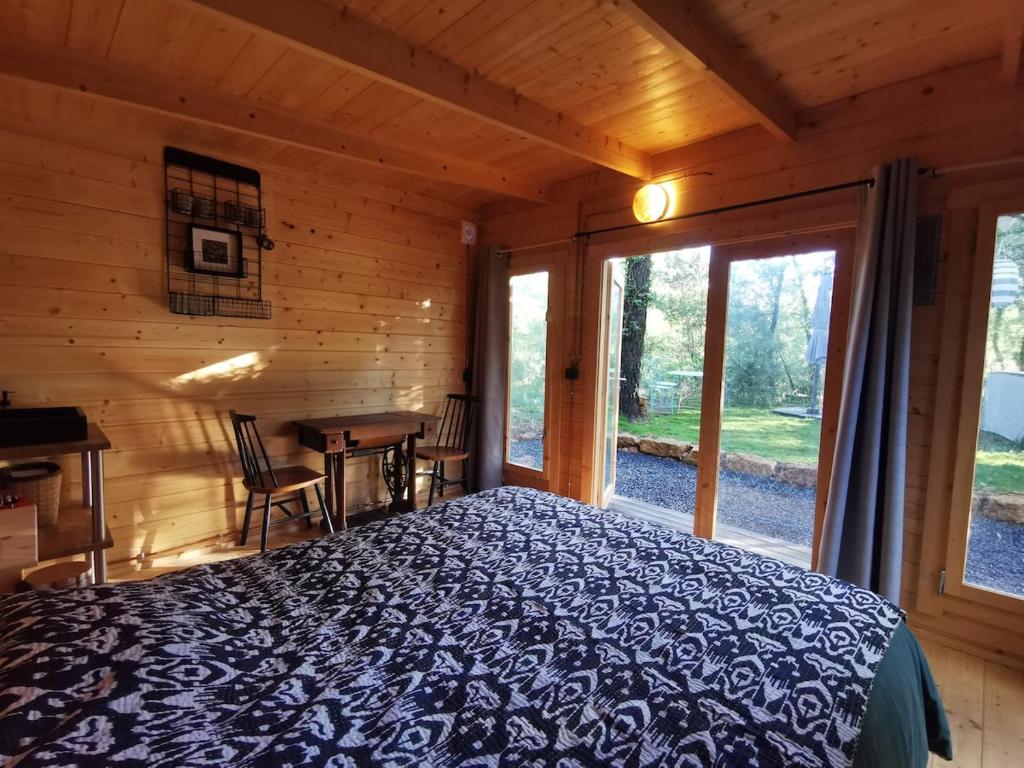 Un dormitorio con una cama en una cabaña de troncos en House surrounded by nature, en Callian