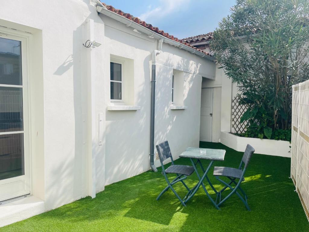 - une petite terrasse avec 2 chaises et une table dans l'établissement Le Petit Saintonge - Cour Privée, à Saintes