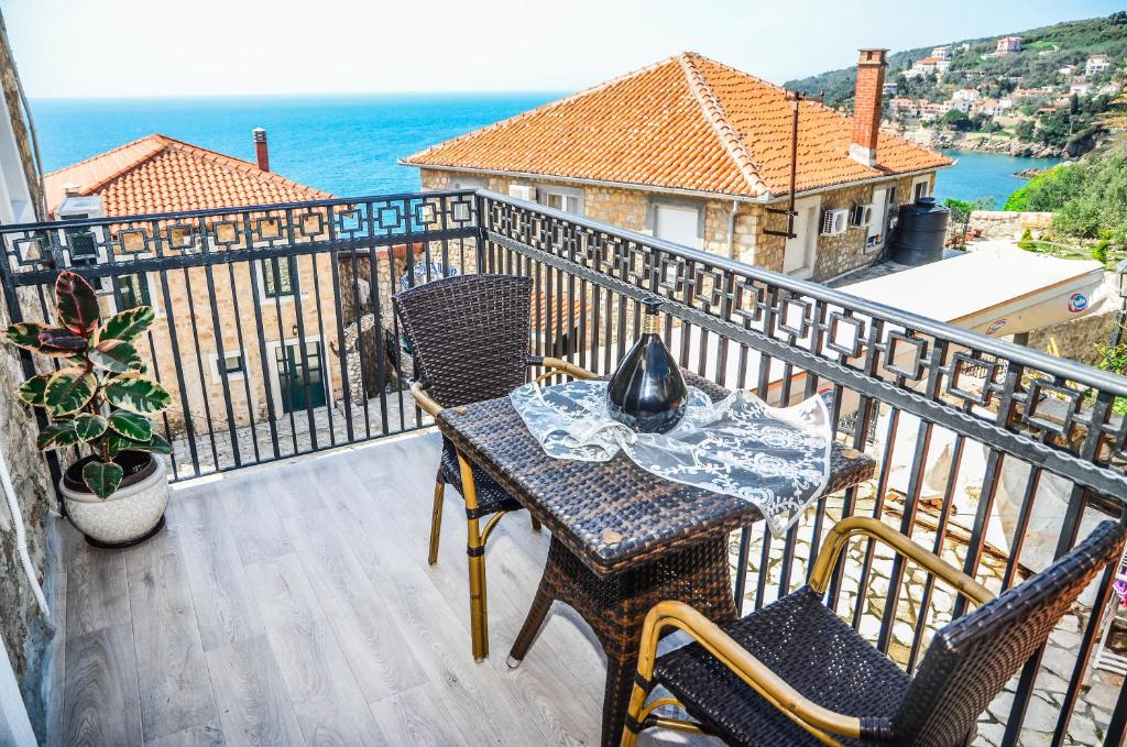 een balkon met een tafel en stoelen en de oceaan bij Guest House Alea in Ulcinj