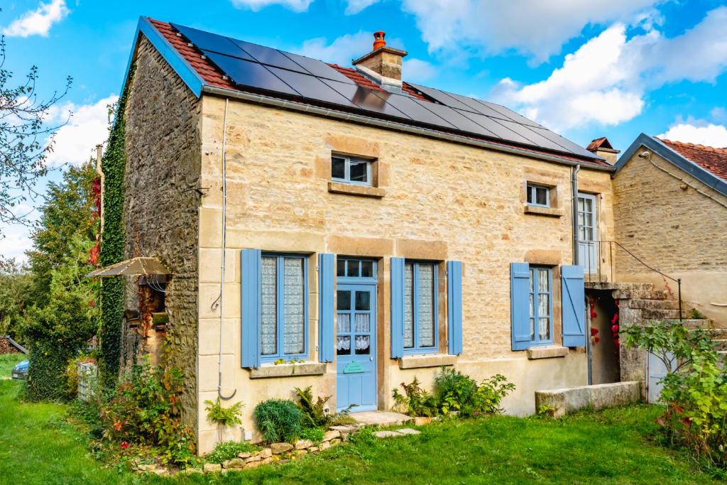 Une vieille maison en briques avec volets bleus dans l'établissement La maison de Germaine, à Planay