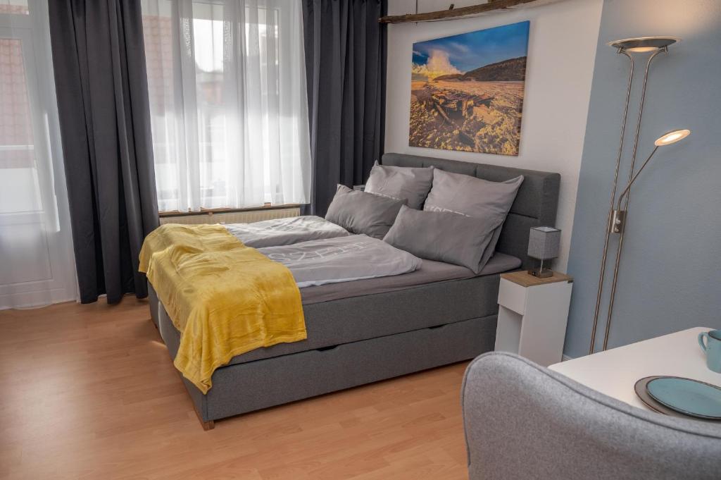 a bedroom with a bed with a yellow blanket on it at Treibholz in Norderney