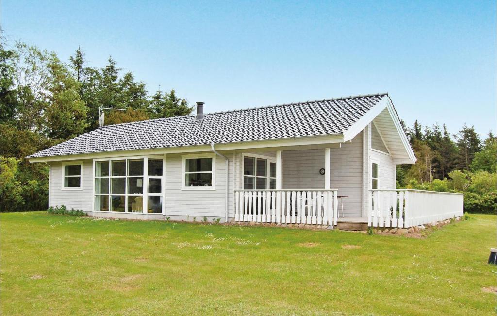 ein weißes Haus mit einem weißen Zaun in einem Hof in der Unterkunft Holiday Home Ålbækparken Spøttrup Ii in Ålbæk