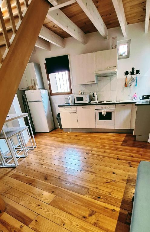 une cuisine avec des appareils électroménagers blancs et du parquet dans l'établissement Appartement de charme centre Collioure, à Collioure