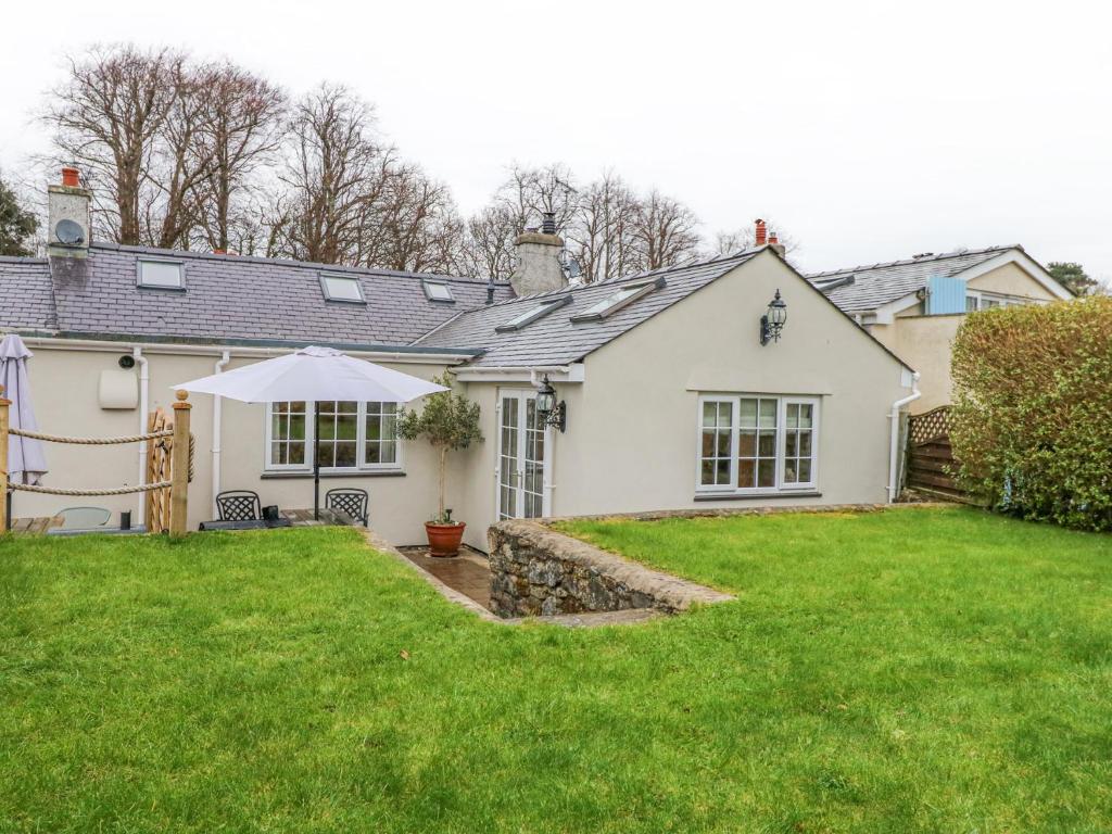 a white house with a lawn in front of it at Bramley Cottage in Beaumaris