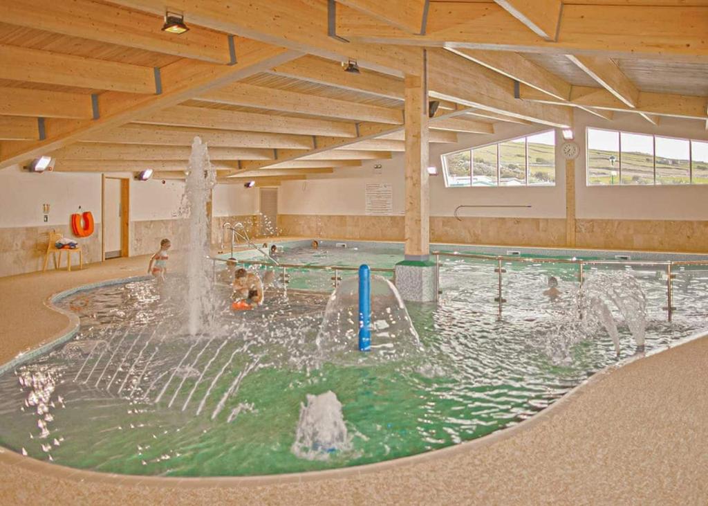 a swimming pool with a fountain in the middle at Sunbeach Holiday Park in Llwyngwril