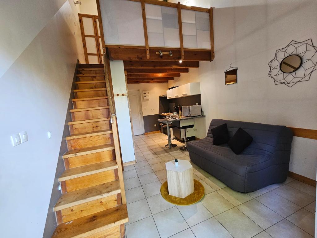 - un salon avec un canapé bleu et un escalier dans l'établissement Gîte Les Mirabelliers L'Escapade Des Flamants Roses, à Mireval