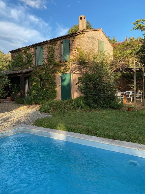 une maison et une piscine devant une maison dans l'établissement Les Arbousiers - villa climatisée avec piscine, au calme, à La Londe-les-Maures