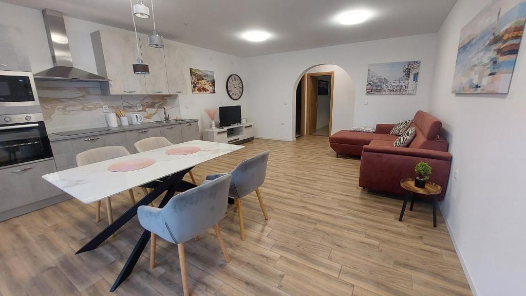 a kitchen and a living room with a table and chairs at Apartment Modrić Zadar II in Zadar