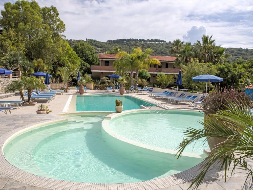 una gran piscina en un complejo con sombrillas azules en Apartment Heaven-2 by Interhome, en Santa María