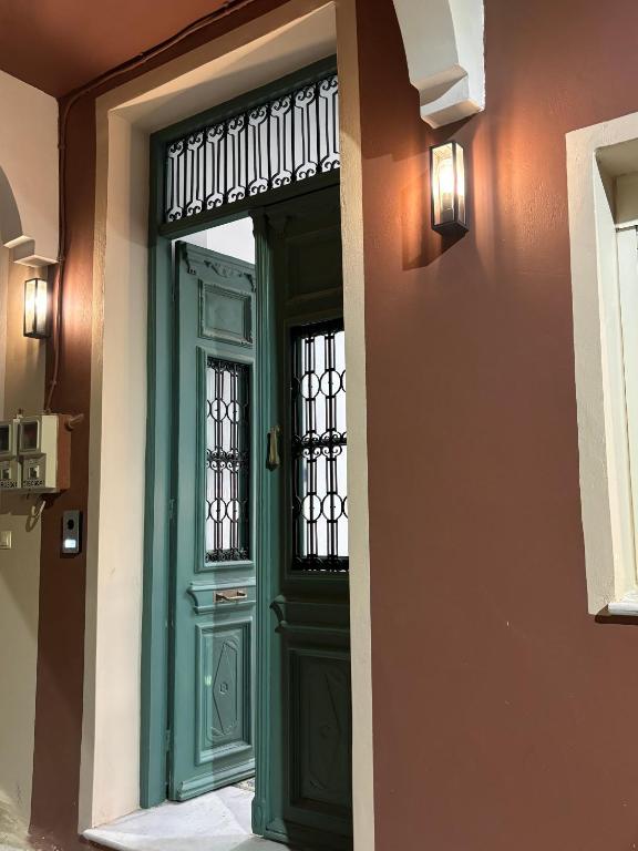 a green door with a window in a building at Villa Rosa in Plomari