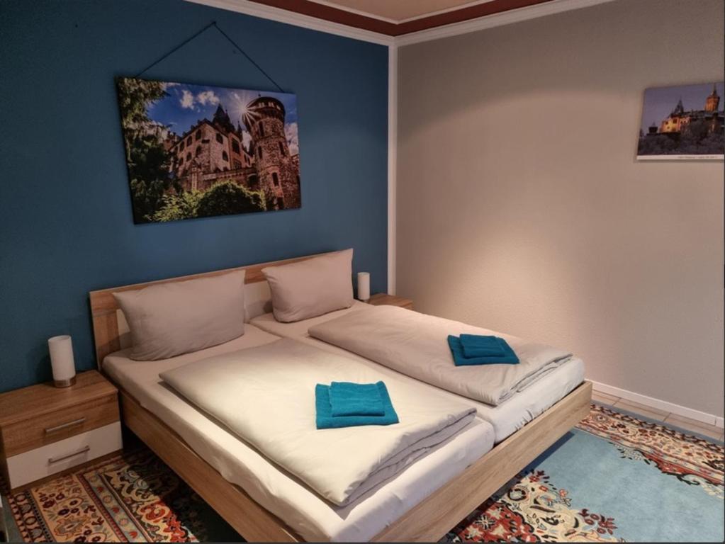 a bedroom with a bed with two blue pillows on it at Ferienhaus "Am Schlossbühel" für 9 Personen in Wernigerode