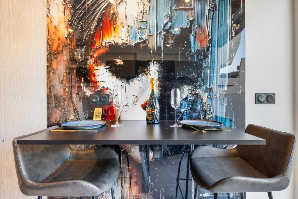 - une table avec 2 chaises et une bouteille de vin dans l'établissement Le Volcanic - Coursives - Port Nature 2, au Cap d'Agde