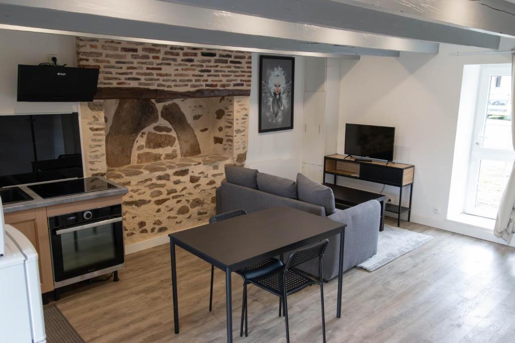 a living room with a couch and a table at studio proche zenith et clinique in Saint-Herblain