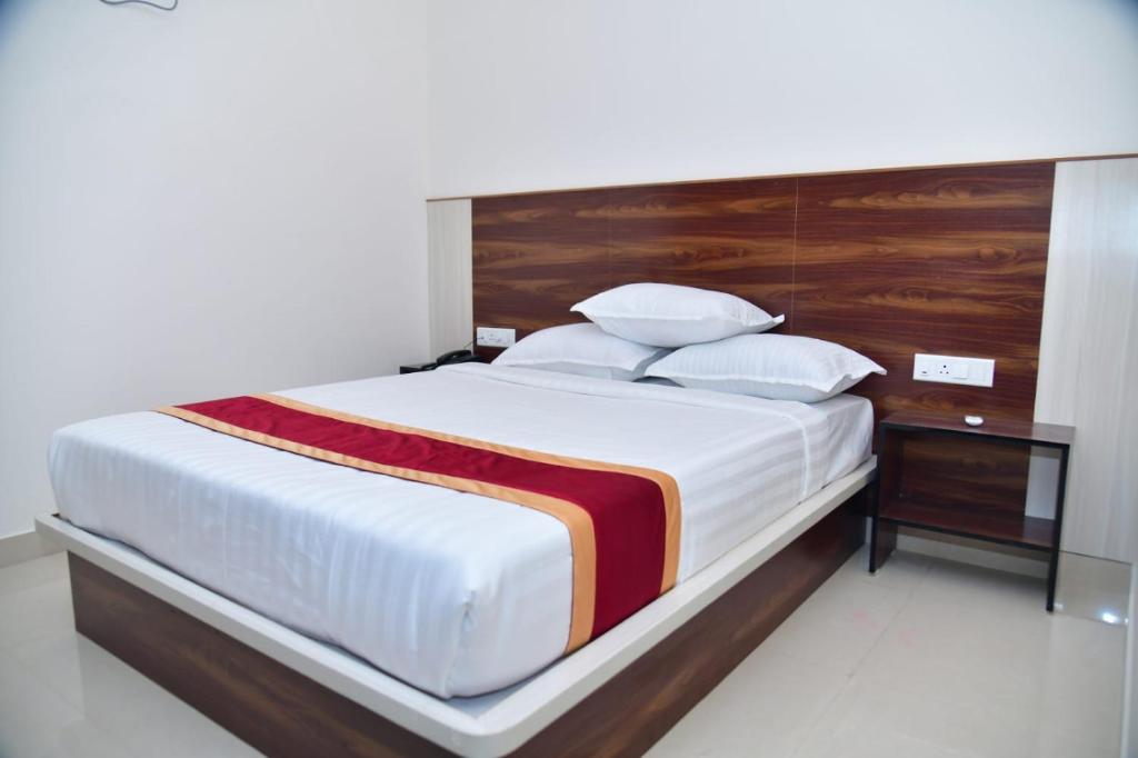 a bedroom with a large bed with a wooden headboard at Golden Keys in Bengaluru