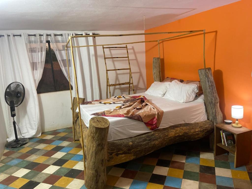 a bedroom with a bed with a metal frame at La ferme de babacar in Toubab Dialaw