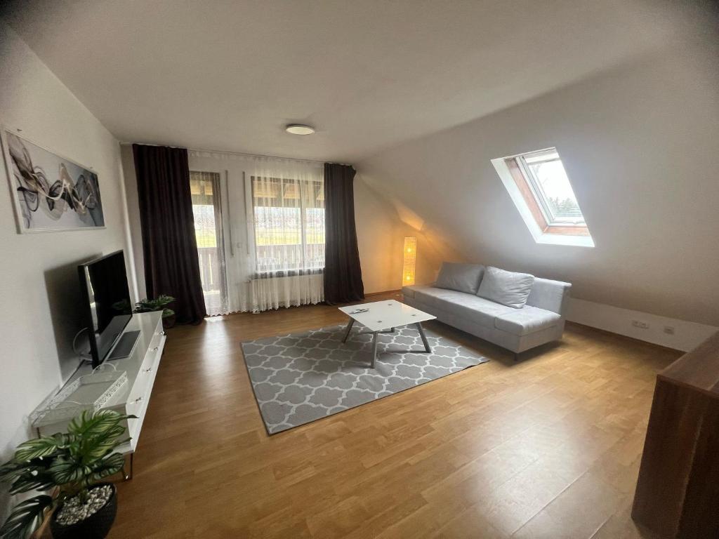 a living room with a couch and a tv at Ferienwohnung KäLi in Pleinfeld