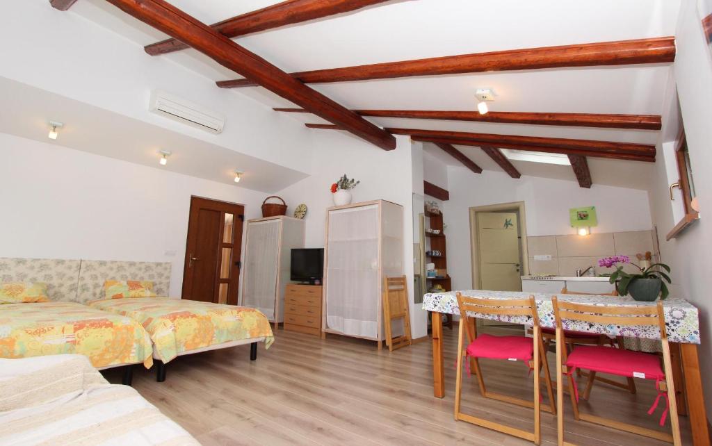 a bedroom with two beds and a table and chairs at Studio Rovinj Home in Rovinj