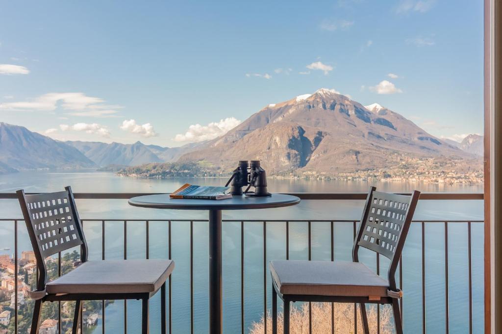 a table and chairs on a balcony with a view of a mountain at Veloccino del Lago in Perledo
