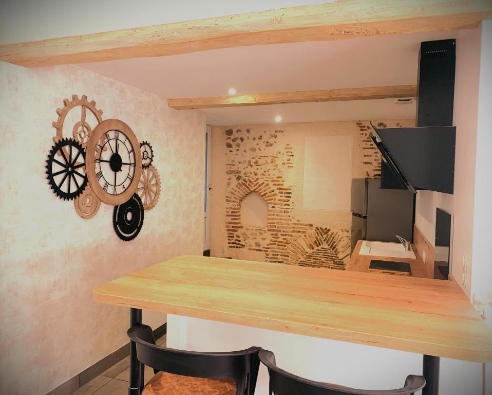 une cuisine avec une table en bois et un mur dans l'établissement L'écureuil, à Châteauneuf-sur-Loire