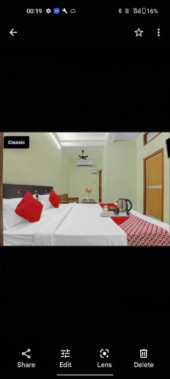 a picture of a bedroom with a bed with red pillows at Hotel khushboo Regency in Deoria