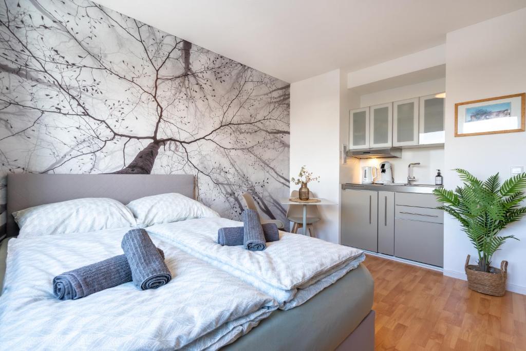 Hotel HoliDeis Cologne City Club-Apartment, a bedroom with a white bed with a tree mural on the wall at HoliDeis Cologne City Club-Apartment in Cologne