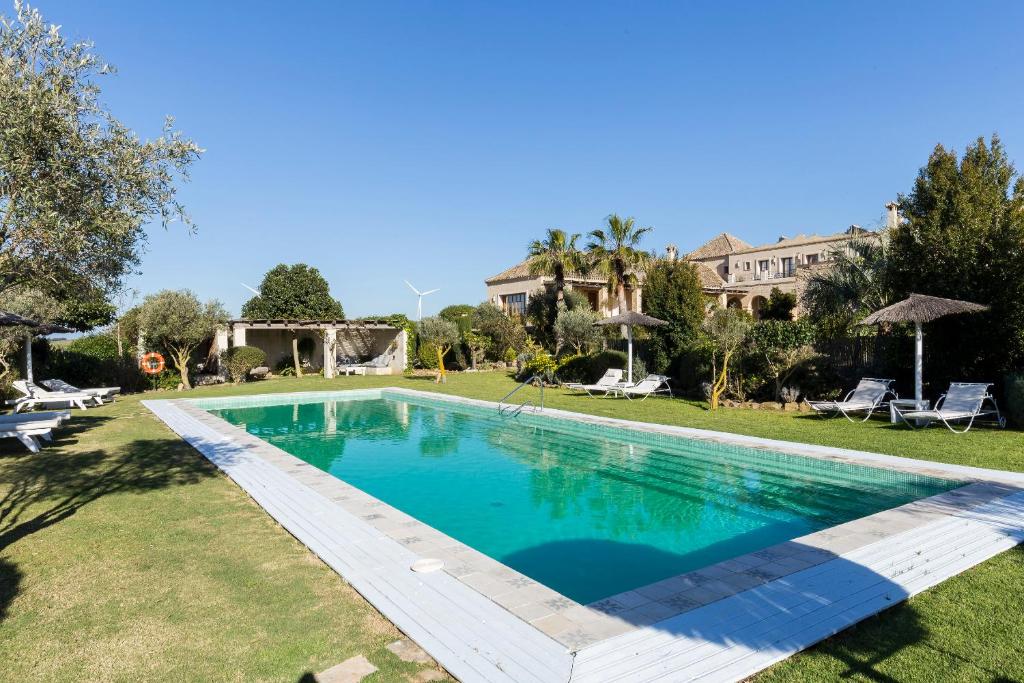 a swimming pool in the yard of a house at Casa La Siesta in Vejer de la Frontera