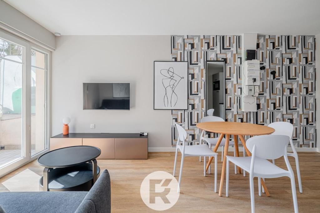 un salon avec une table et des chaises dans l'établissement R'Apparts La Suite D'Albert T2, à Grenoble