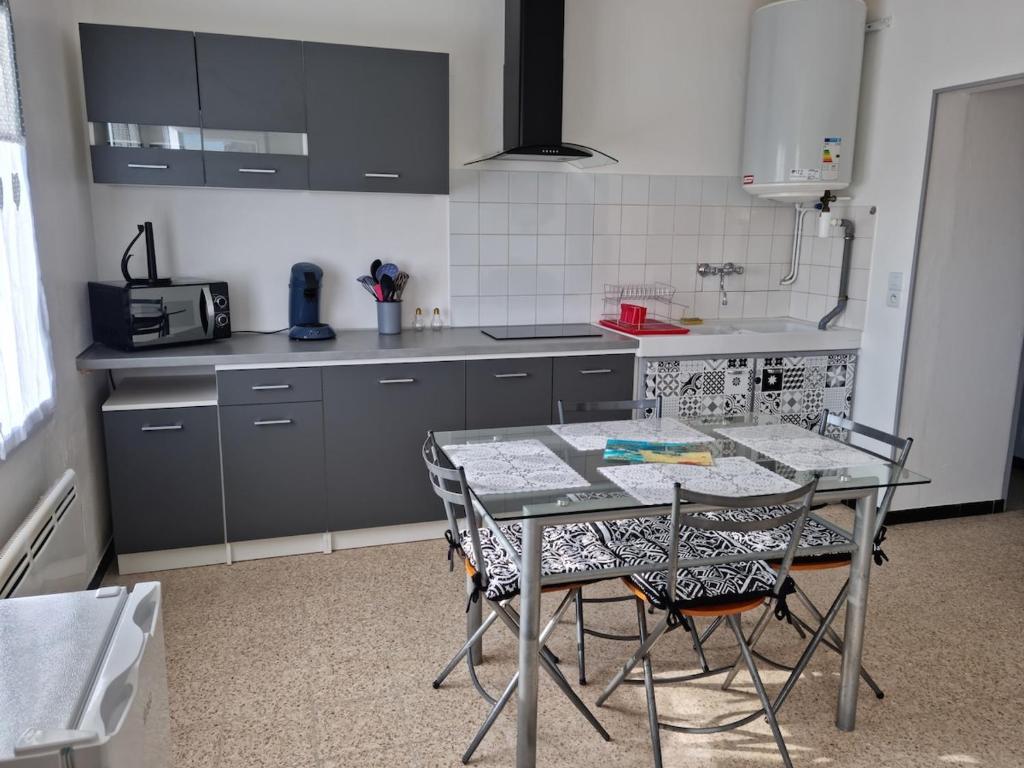 a kitchen with a table and chairs in it at Appartement au coeur du perche in Val-au-Perche